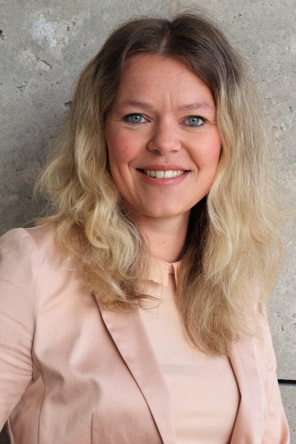 Ein Portrait der Ehrenamtskoordinatorin Julia Grigor. Sie trägt ein roséfarbendes Sakko.