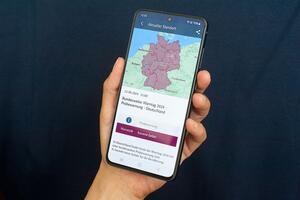 Ein Handy mit einer App, die eine Deutschlandkarte zeigt.